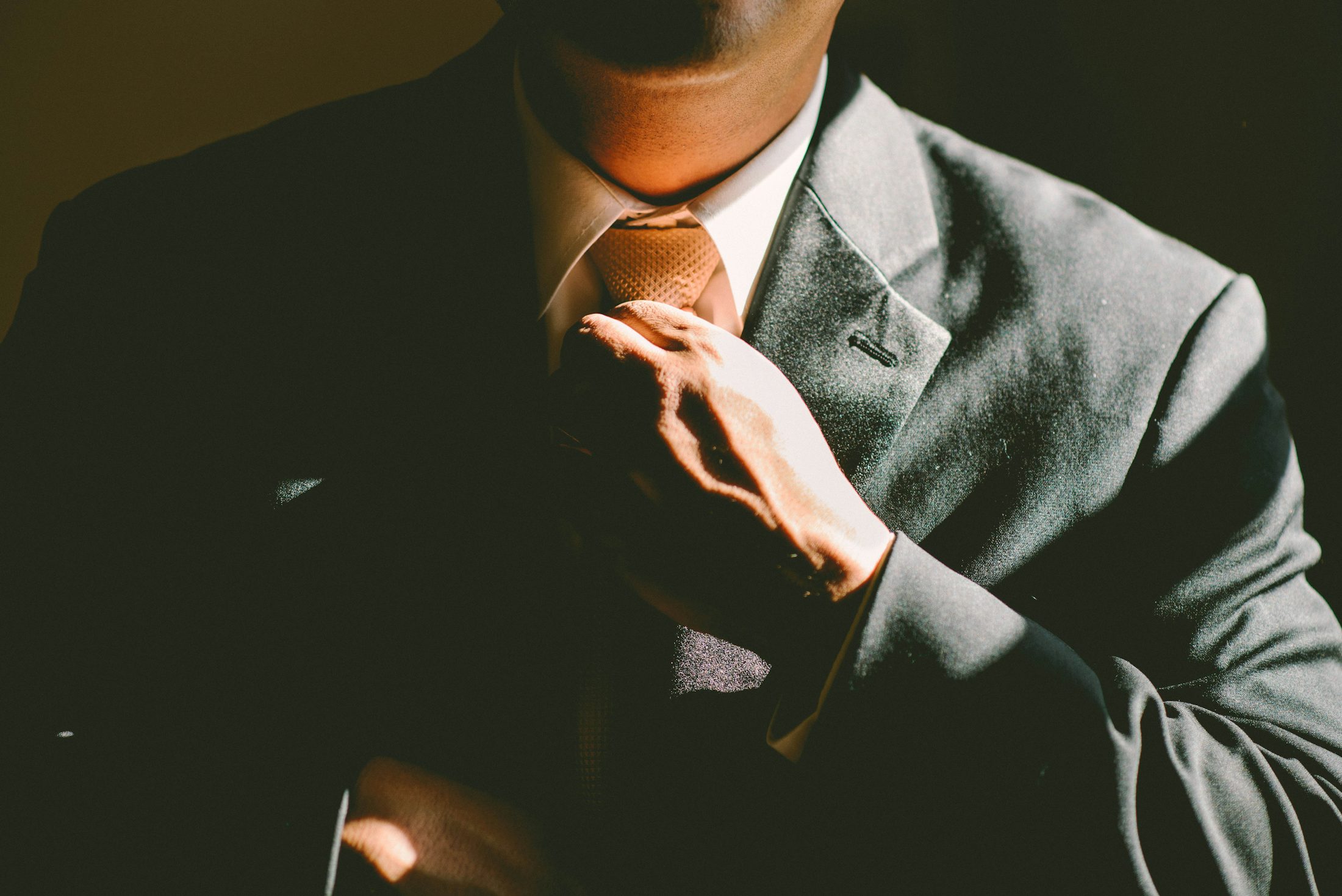 Executive finance advisor adjusting a gold tie